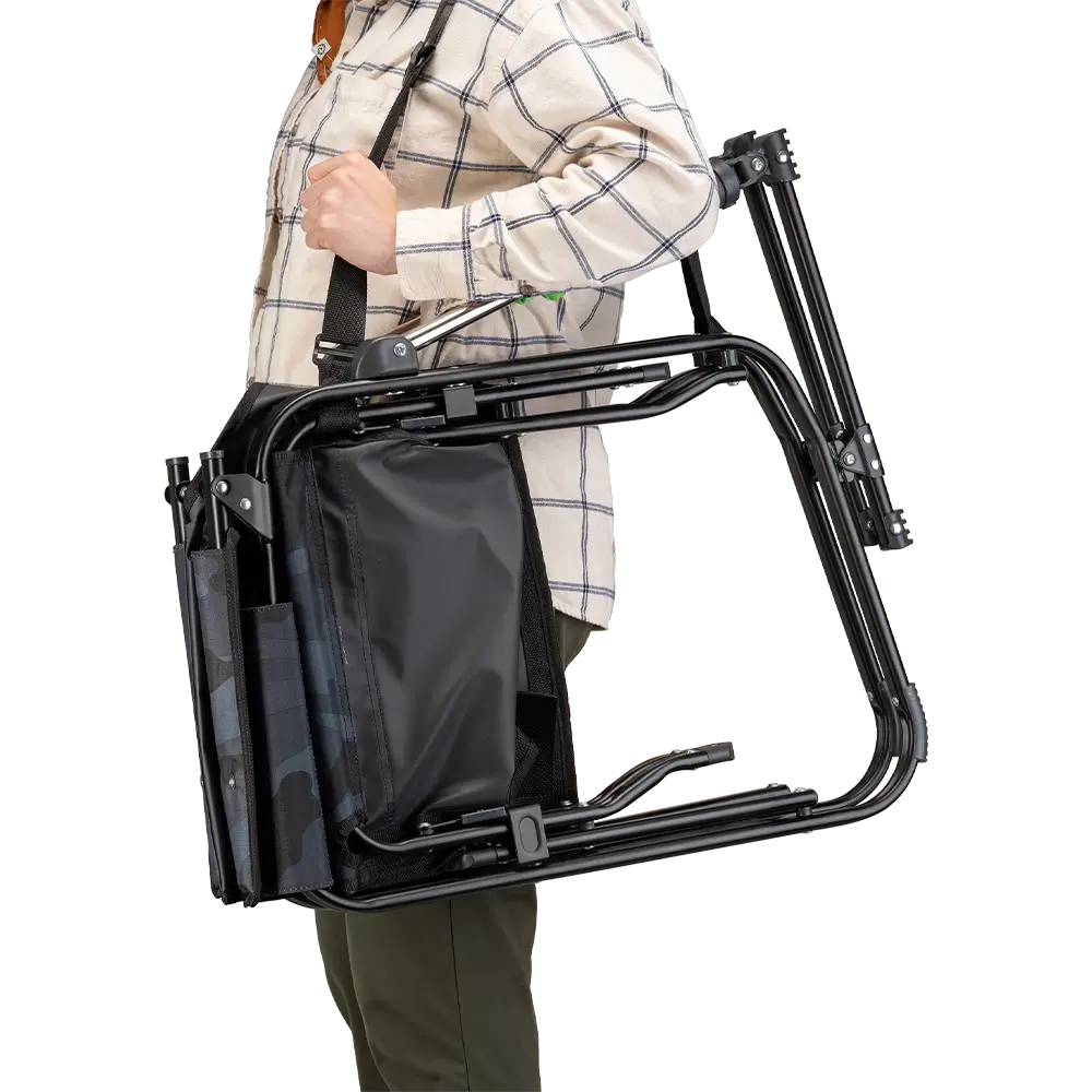 A person carrying the Stealth Camo Stowaway Rocker with a carry strap. 